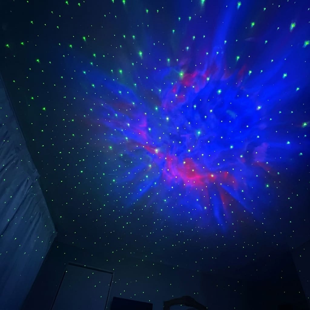 blue and red nebula and stars display projected onto dark ceiling